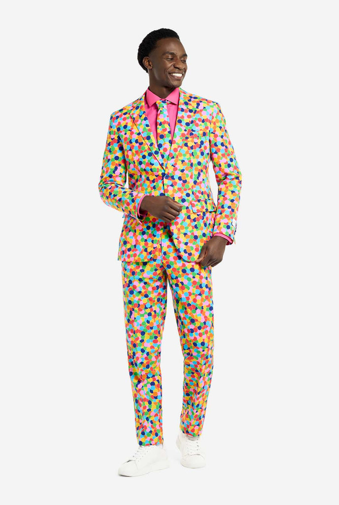 Image of a man wearing an OppoSuits Confetteroni men's suit with confetti print and pink men's shirt. Suit consist of pants, jacket and tie.