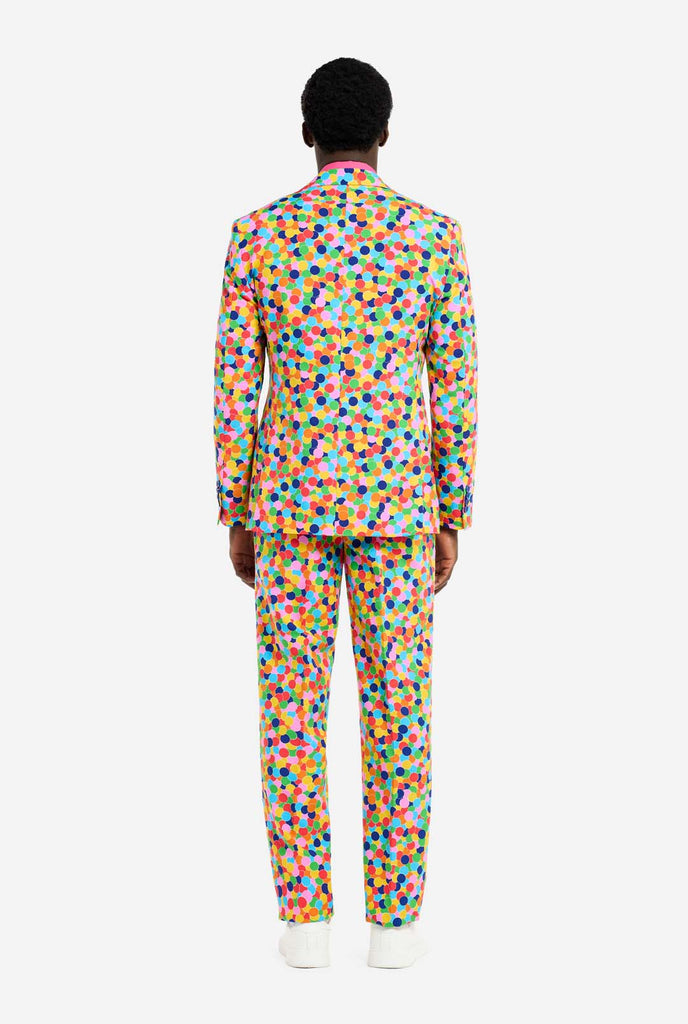 Image of a man wearing an OppoSuits Confetteroni men's suit with confetti print and pink men's shirt. Suit consist of pants, jacket and tie.