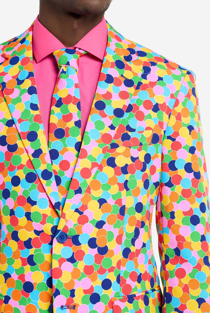 Image of a man wearing an OppoSuits Confetteroni men's suit with confetti print and pink men's shirt. Suit consist of pants, jacket and tie.