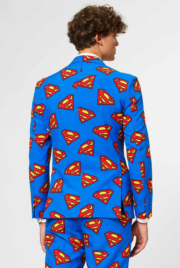 Man wearing blue men's suit with Superman logo print