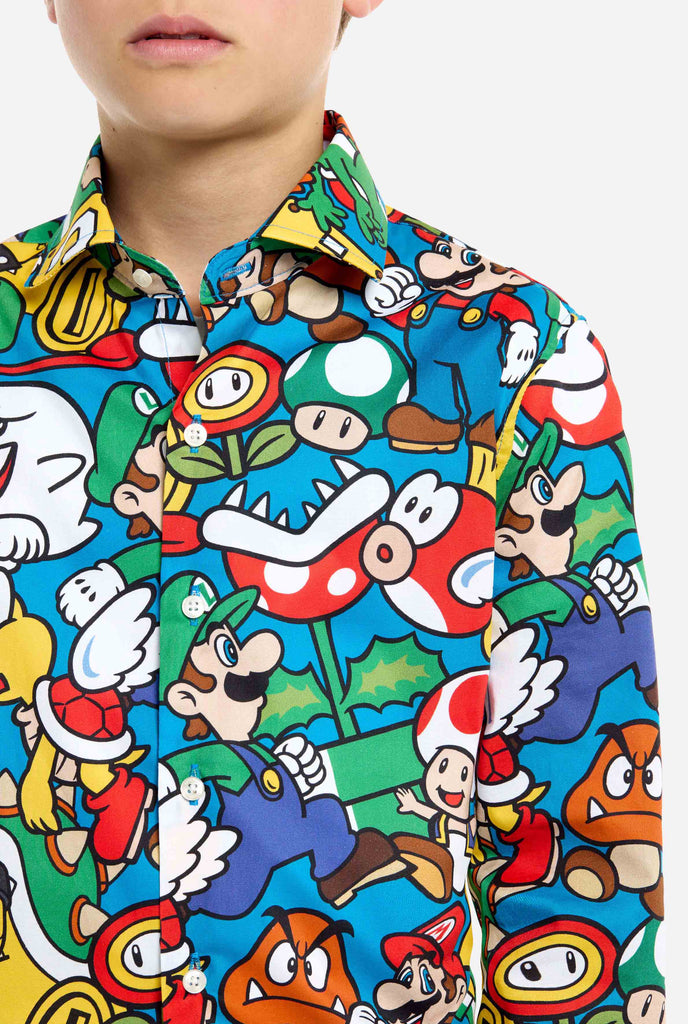 Image of teen wearing a Super Mario all over print shirt. Main color is blue, but there is also yellow, red and white.