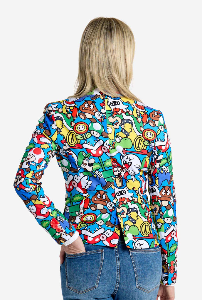 Woman wearing all-over print Super Mario blazer with iconic Super Mario characters. The base is light blue, but there is also yellow, red and white.