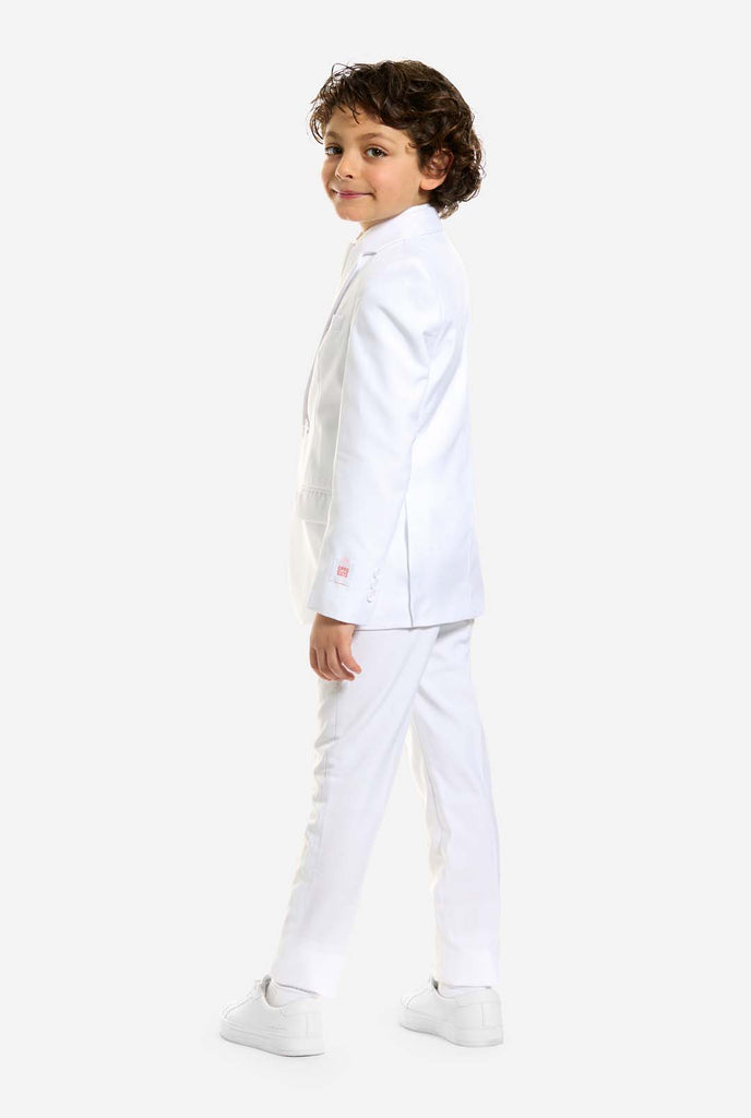 In this image, a kid is wearing a white suit for boys and white shirt. The consists of jacket, pants and clip-on tie.