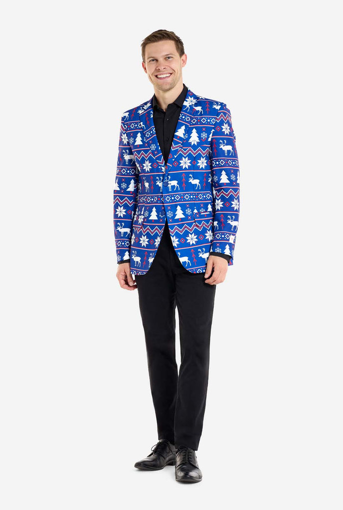 Man wearing blue Christmas blazer for men with Nordic Christmas figures. Man also wearing a black pants and black men's shirt. Full body image.