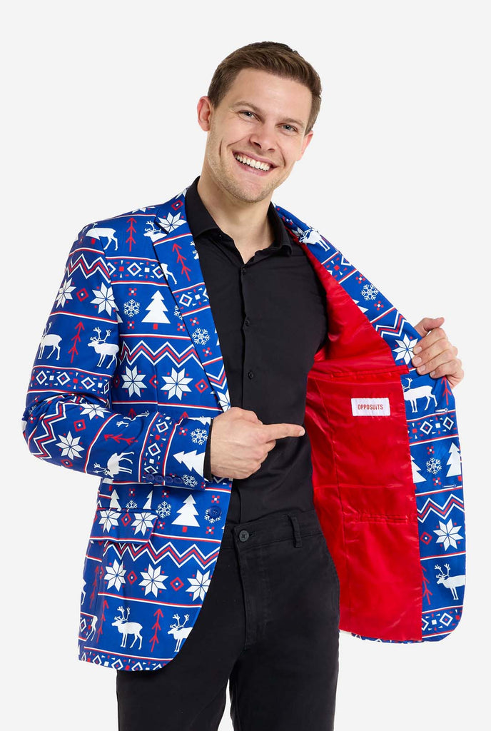 Man wearing blue Christmas blazer for men with Nordic Christmas figures. Man also wearing a black pants and black men's shirt. Showing the red inside of the jacket.