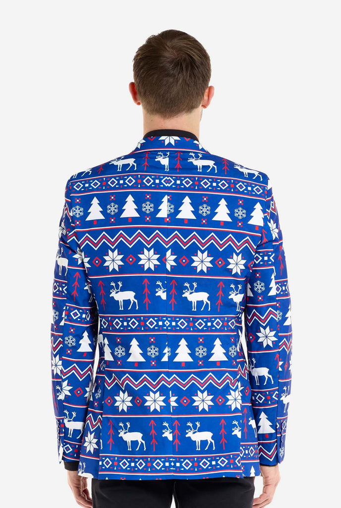 Man wearing blue Christmas blazer for men with Nordic Christmas figures. Man also wearing a black pants and black men's shirt. View from the back.