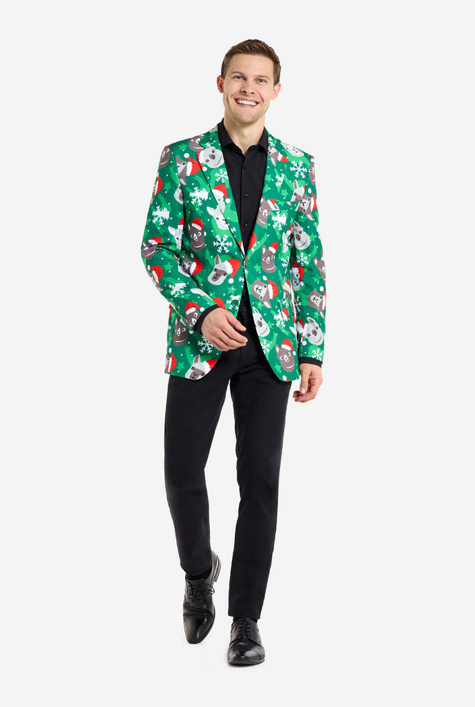 Man wearing green Christmas blazer for men with Christmas llamas. Man also wearing a black pants and black men's shirt. Full body image.