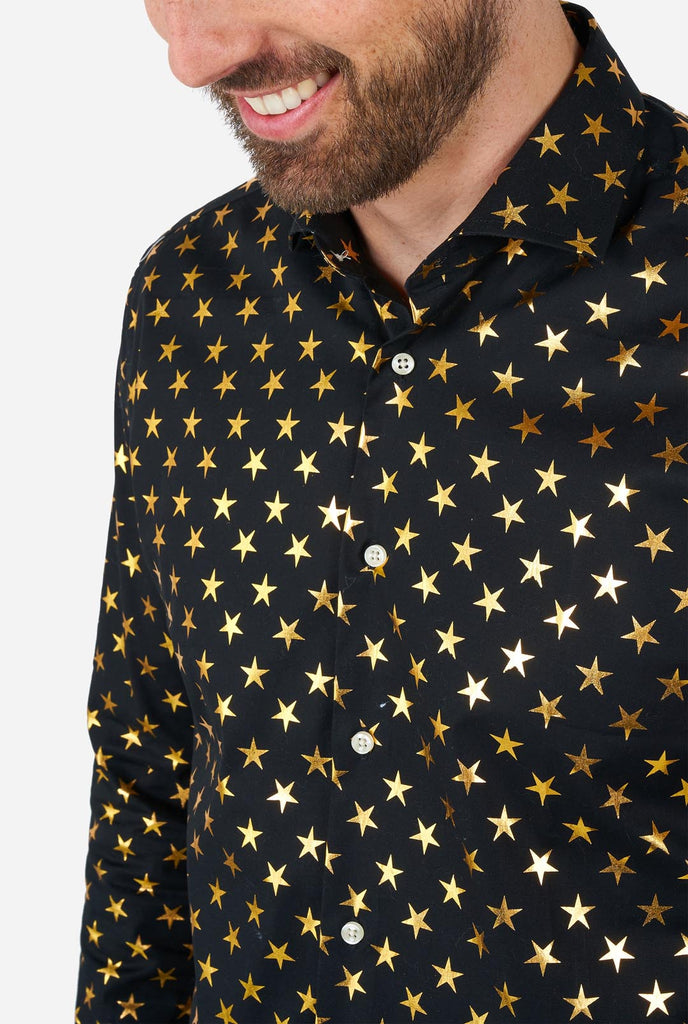 This image showcases a stylish men's dress shirt from OppoSuits, designed with a black base adorned with an eye-catching gold star pattern. The shirt has a sleek and contemporary fit, perfect for those who want to add a touch of flair to their wardrobe. Ideal for festive occasions, parties, or making a bold statement, this shirt combines elegance with a unique, playful twist.  Chest close-up.