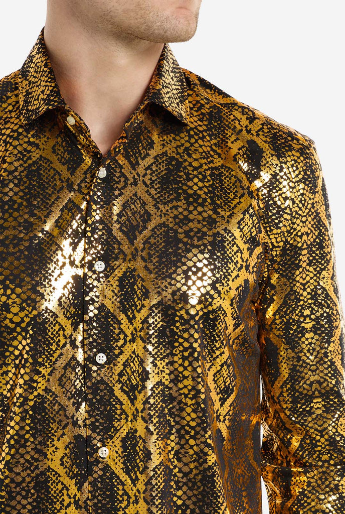 This image showcases a men’s dress shirt from OppoSuits, featuring a striking gold and black snakeskin print pattern. The shirt’s fabric has a glossy finish that reflects light, creating a bold, high-fashion look perfect for making a statement. With a detailed reptile-inspired pattern, this shirt is ideal for anyone looking to bring some edgy style to their wardrobe. Close up.