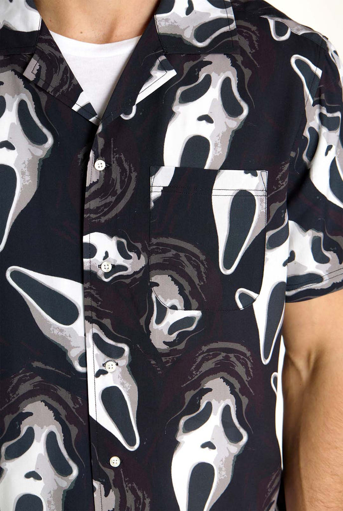 Man wearing black Hawaiian shirt with Ghostface print, close up