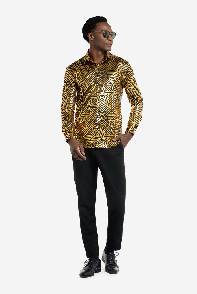 This image features a men’s shirt from OppoSuits with a vibrant gold and black geometric star print pattern. The shirt has a reflective finish that highlights the intricate star and line designs, creating a dynamic and stylish look. Perfect for those who want to stand out, this shirt is both bold and fashionable, ideal for parties, holiday celebrations, or nightlife. The model wears it paired with black pants, and sunglasses.