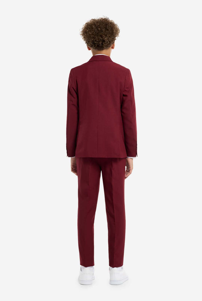 Teen wearing formal burgundy red suit, view from the back