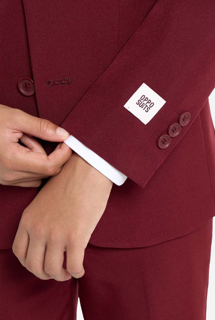 Teen wearing formal burgundy red suit, close up