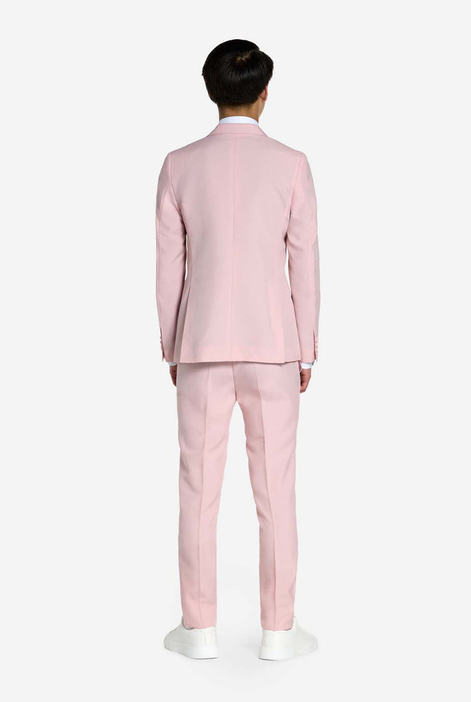 Teen wearing soft pink teen boys suit, view from the back.