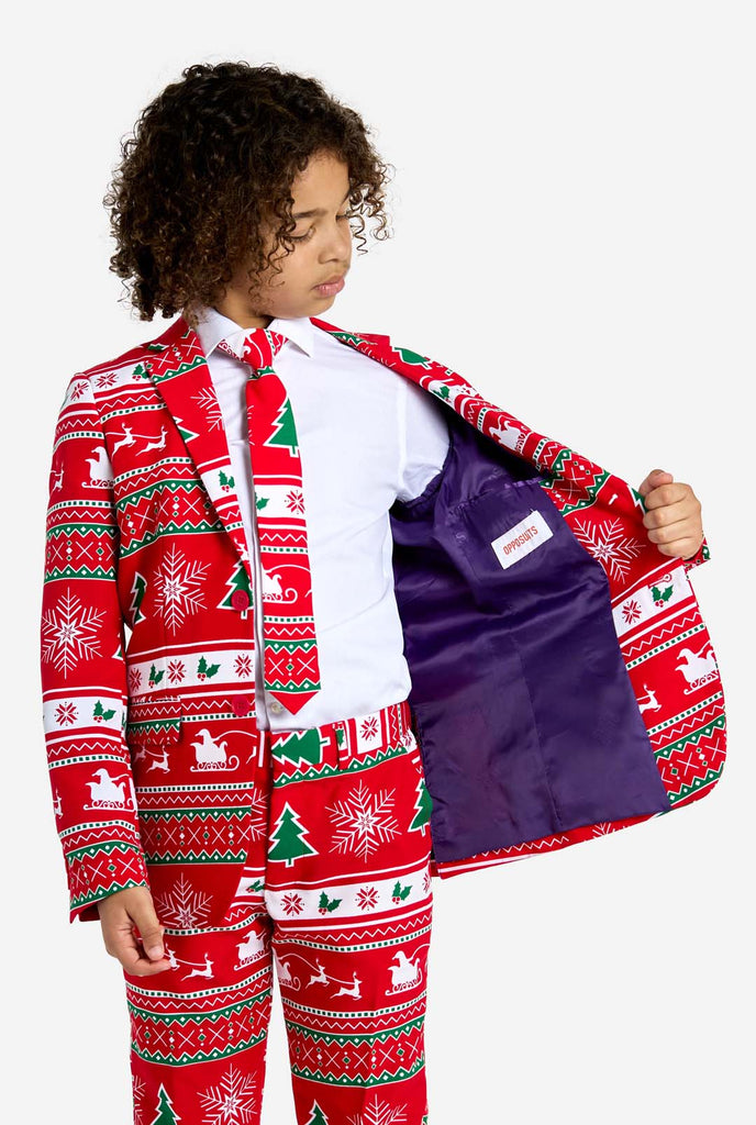 Teen wearing red Christmas suit with green and white Christmas icons, like Christmas tree, snowflakes, holly and sled with reindeers.