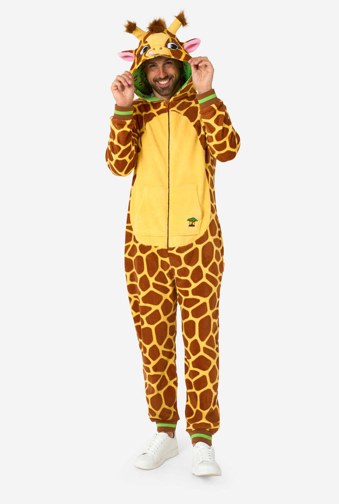 A smiling man is wearing a brown and yellow adult onesie designed as a giraffe. The onesie features a hood resembling a Giraffes head, and giraffe details, perfect for cozy lounging or costume parties. Full body image.