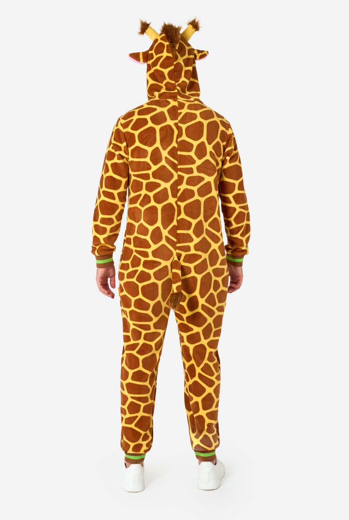 A smiling man is wearing a brown and yellow adult onesie designed as a giraffe. The onesie features a hood resembling a Giraffes head, and giraffe details, perfect for cozy lounging or costume parties. Full body image showing the back of the onesie.