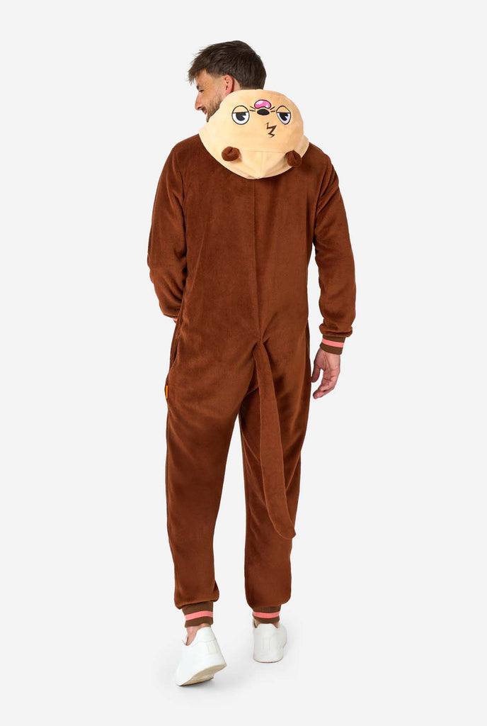 A smiling man is wearing a brown adult onesie designed as an otter. The onesie features a hood with ears, a cute face, and playful otter details, perfect for cozy lounging or costume parties. Full body image showing the back of the onesie.