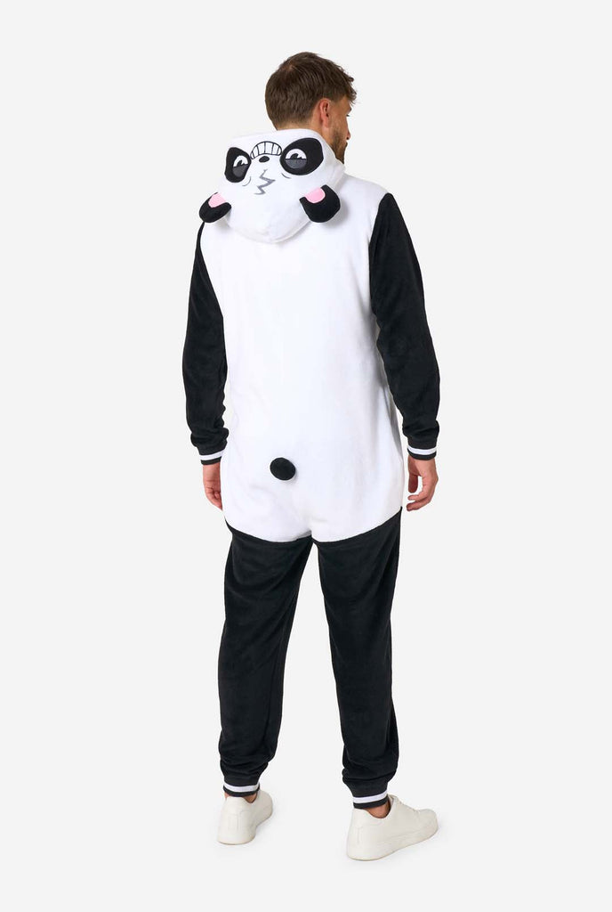 A smiling man wearing a panda-themed adult onesie. This cozy onesie features black and white panda colors with a playful hood showcasing panda ears and a cute face. Perfect for lounging or fun costume occasions. Full body image from the back, with the hood down. 