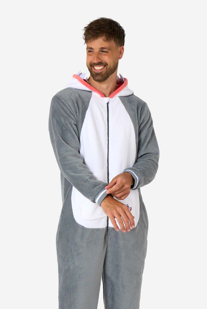 A man is wearing a grey and white shark adult onesie featuring playful hood details and cozy, soft material, perfect for lounging or costume events. Hood down on the man's back.