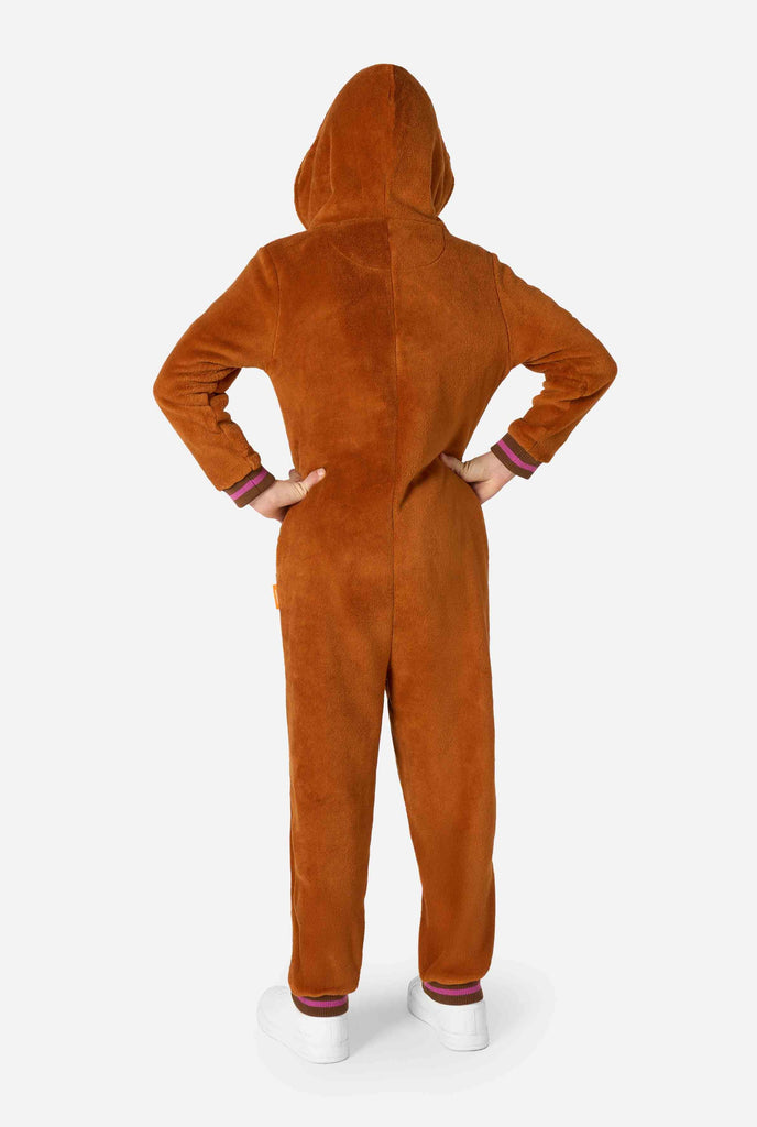 A cheerful kid wearing a brown kids onesie designed as a walrus. The onesie features a hood with fangs, stitched gloves resembling paws, and playful walrus details, perfect for cozy lounging or costume parties. View from the back.