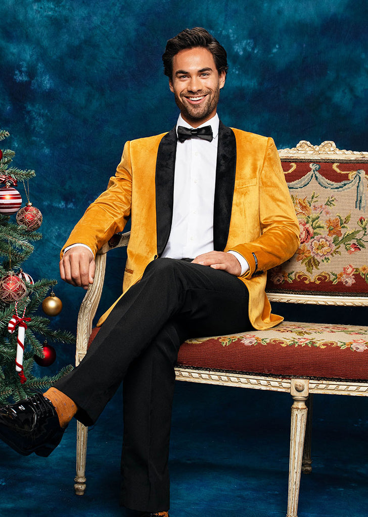 Man sitting on sofa wearing velvet golden smoking jacket